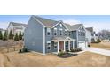 A two-story blue house displaying a landscaped yard, an attached two-car garage, and a welcoming front porch at 1620 Callahan Rd, Fort Mill, SC 29715