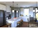 Bright kitchen features a large island with seating, white cabinetry, modern appliances, and stylish pendant lighting at 1821 Country Club Rd, Wadesboro, NC 28170