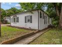 Well-maintained home showcasing brick accents, manicured lawn, and charming walkway at 207 Eden St, Davidson, NC 28036