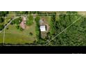 Aerial view of the property showcasing a large lot, house, and metal garage surrounded by lush trees at 2500 Cedar Cove Dr, Harrisburg, NC 28075