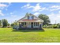 Charming home featuring a covered front porch with an American flag, perfect for relaxing and enjoying the outdoors at 35 Telephone Exchange Rd, Hickory, NC 28601