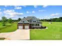 Beautiful exterior featuring a well-maintained lawn, two-car garage, and inviting front porch at 3707 Seagrave Farm Rd, Concord, NC 28025