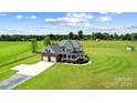 Stunning aerial view of a home with a large yard, two-car garage, and covered front porch at 3707 Seagrave Farm Rd, Concord, NC 28025