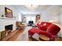 Inviting living room with a brick fireplace, hardwood floors, and built-in bookshelves at 501 Pee Dee Ave, Albemarle, NC 28001