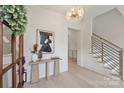 Bright foyer featuring light hardwood floors, a modern chandelier, a console table, and staircase at 536 Hillside Ave, Charlotte, NC 28209