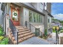 Inviting front porch with brick steps, black railings, a wooden door with wreath, and multiple windows at 536 Hillside Ave, Charlotte, NC 28209