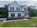 Beautiful two-story home featuring a modern farmhouse design and lush green lawn at 5630 Galloway Dr # 49, Stanfield, NC 28163