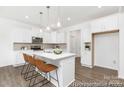 Modern kitchen with white cabinets, marble countertops, and a stylish island with seating at 5630 Galloway Dr # 49, Stanfield, NC 28163