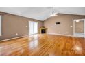 Spacious living room featuring hardwood floors, fireplace, ceiling fan, and lots of light at 5678 Cedar Run Dr, Denver, NC 28037