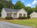 View of exterior with vinyl siding, a gravel driveway and manicured landscaping at 6022 Windsong Way, Wingate, NC 28174