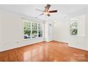 Bright living room with hardwood floors, large window offering street views, and a ceiling fan at 6429 Terrace View Ct, Charlotte, NC 28269