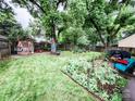 Large backyard features a playhouse, vegetable garden, mature trees, and space for entertaining at 7321 Mapleridge Dr, Charlotte, NC 28210