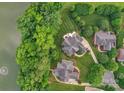 Aerial view of upscale homes with lush landscaping and mature trees, near a serene lake at 7501 Cleyera Cir, Waxhaw, NC 28173
