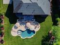 Aerial view of a home showcasing a backyard oasis with pool, patio, deck, and lush landscaping at 7507 Meadowgate Ln, Waxhaw, NC 28173