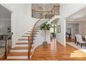 Open foyer featuring a curved staircase, hardwood floors, and a view into the adjacent living spaces at 7507 Meadowgate Ln, Waxhaw, NC 28173