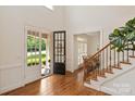 Bright foyer with hardwood floors, staircase with iron railings and a view to the front yard at 7507 Meadowgate Ln, Waxhaw, NC 28173