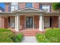 Inviting front porch with double doors, classic columns, and beautiful landscaping at 7507 Meadowgate Ln, Waxhaw, NC 28173