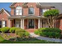Inviting front porch with columns, arched windows and decorative landscaping, welcoming visitors to the home at 7507 Meadowgate Ln, Waxhaw, NC 28173