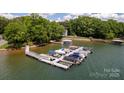 Large dock featuring multiple boat slips surrounded by lush greenery and lake views at 8024 Bradford Ln, Denver, NC 28037