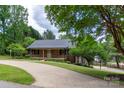 Charming brick home with lush landscaping, a long driveway, and a welcoming front porch at 8024 Bradford Ln, Denver, NC 28037