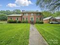 Charming brick home with a well-maintained lawn and walkway to front door at 824 Balsam Ter, Charlotte, NC 28214