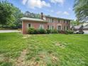 Traditional brick home with green shutters, a neatly landscaped lawn, and a driveway at 824 Balsam Ter, Charlotte, NC 28214