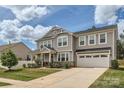Beautiful two-story home boasts an attached two-car garage and lush green lawn at 8726 Addingham Dr, Charlotte, NC 28269