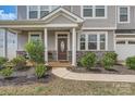 Inviting front porch with stone accents, lush landscaping, and an elegant front door at 8726 Addingham Dr, Charlotte, NC 28269