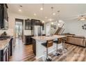 Open-concept kitchen with dark cabinetry, granite countertops, and stainless steel appliances, adjacent to the living room at 8726 Addingham Dr, Charlotte, NC 28269