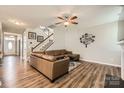 Spacious living room featuring wood floors, a comfortable leather sofa, and stylish decor at 8726 Addingham Dr, Charlotte, NC 28269