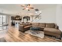 Spacious living room features a leather sectional, wood floors, and an open layout flowing into the kitchen at 8726 Addingham Dr, Charlotte, NC 28269
