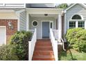 Inviting front porch with wooden steps and white railings leading to a blue front door at 9315 Pebble Creek Way, Charlotte, NC 28269