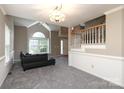 Cozy living room featuring a vaulted ceiling, large window, and open staircase at 9315 Pebble Creek Way, Charlotte, NC 28269