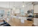 A modern kitchen with granite countertops, stainless steel appliances, and pendant lighting over the island at 10401 Royal Winchester Dr, Charlotte, NC 28277