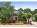 Charming two-story brick home with lush landscaping, a red front door, and a well-maintained lawn at 10616 Back Ridge Rd, Charlotte, NC 28277