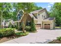 Exterior view of a home showcasing a spacious driveway leading to the garage and a well-maintained landscaped yard at 1328 Huntcliff Dr, Waxhaw, NC 28173