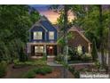 Charming two-story home featuring a mix of brick and blue siding, a welcoming porch, and lush landscaping at 1328 Huntcliff Dr, Waxhaw, NC 28173
