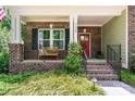 Inviting front porch with brick pillars, an iron railing, and a cozy bench, creating a welcoming entryway at 1328 Huntcliff Dr, Waxhaw, NC 28173