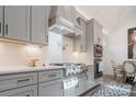Bright kitchen featuring stainless steel appliances, modern countertops, white cabinets, and tile backsplash at 1428 Spring Ridge Ln, Denver, NC 28037