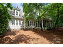 Back exterior view featuring screened porch, large windows, manicured lawn and mature trees at 154 Patterson'S Bridge None, New London, NC 28127
