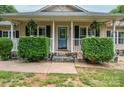 Inviting front porch with stone accents, manicured bushes, and a blue front door with glass detail at 1774 Smyrna Ln, Catawba, NC 28609