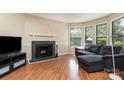 Cozy living room featuring a fireplace, hardwood floors, and large windows that let in ample light at 216 S Clarkson St # E, Charlotte, NC 28202