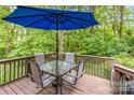 Relaxing outdoor patio with a blue umbrella and table with seating, nestled in a green, wooded area at 2339 Wednesbury Ct, Kannapolis, NC 28083
