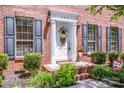 Up-close view of front door framed by black shutters, tasteful landscaping, and brick facade at 292 Rose St, Mooresville, NC 28117