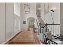 Bright foyer featuring hardwood floors, elegant staircase, and a statement chandelier at 3524 Rhett Butler Pl, Charlotte, NC 28270