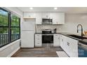 Updated kitchen featuring black countertops, white cabinets, and stainless steel appliances with natural light at 392 Tall Oaks Trl, Fort Mill, SC 29715