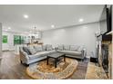 Bright living room features neutral sofas, an accent rug, and a stone fireplace that opens to the kitchen at 392 Tall Oaks Trl, Fort Mill, SC 29715