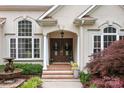 Charming front entrance featuring a double-door entry, decorative columns, and lush landscaping at 400 Maymont Dr, Cramerton, NC 28032