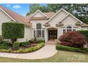 Inviting home exterior with a landscaped garden, a central fountain, and an elegant double-door entrance at 400 Maymont Dr, Cramerton, NC 28032