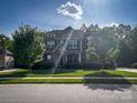 Two story house with stone facade and landscaped front yard on a sunny day at 4006 Tremont Dr, Indian Trail, NC 28079
